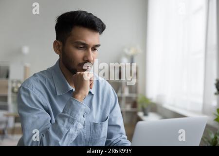 Focused handsome young Indian professional man working at computer Stock Photo