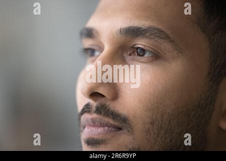 Thoughtful handsome young Indian man facial close up portrait Stock Photo