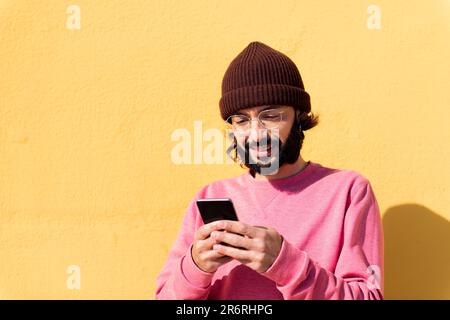 smiling young man using mobile phone Stock Photo