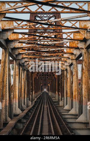 Old rusty iron traditional railway Long Bien bridge structure over the road in Hanoi city at Vietnam Stock Photo