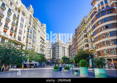 Valencia, Spain - July 15, 2022: A cityscape with buildings, trees and people walking on the sidewalk against a blue sky. Casual Hoteles is written on Stock Photo