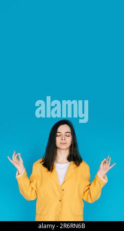 Serene Young Woman Practicing Yoga Meditation - Relaxation, Balance, Mindfulness, Serene Relaxation, Inner Peace, Mindfulness, Isolated on Blue Stock Photo