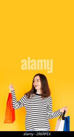 Delighted Shopper Concept: Captivating Woman Excited About Bargains and Discounts, Looking at Empty Space - Shopping Spree Mood Isolated on Vibrant Stock Photo
