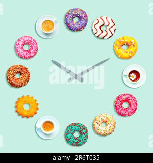 Clock made of colorful donuts, cups and cookies. Time to drink tea. Isolated on a blue background. Stock Photo