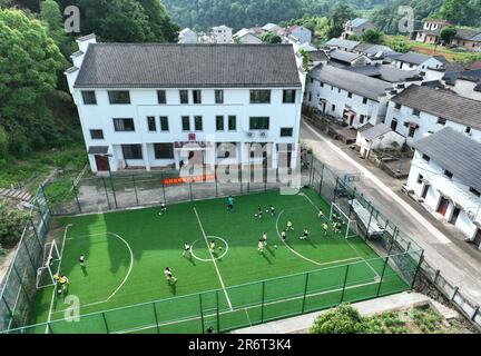 (230611) -- HANGZHOU, June 11, 2023 (Xinhua) -- Primary school students play football in Lipu Town, Zhuji City, east China's Zhejiang Province, May 25, 2023. Since 2003, Zhejiang, located in the Yangtze River Delta, has implemented a rural green revival program to overhaul the living environment of villages, which was granted the UN Environment Program's (UNEP) Champions of the Earth award in September 2018. For twenty years, the program has created thousands of beautiful villages, and fundamentally changed the face of the province's countryside. (Xinhua/Weng Xinyang) Stock Photo