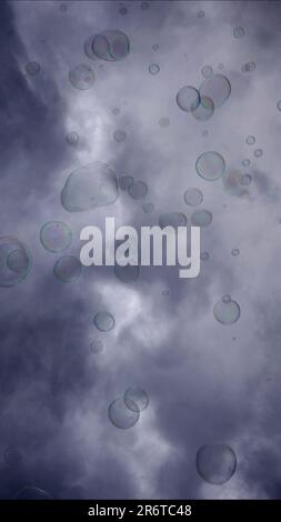 Soap bubbles are flying on gray cloudy sky background Stock Photo