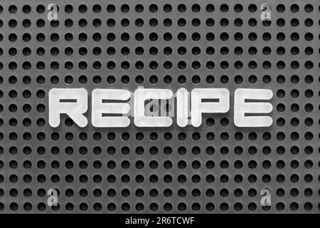 White alphabet letter in word recipe on black pegboard background Stock Photo