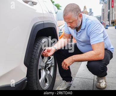 A man changes the wheel of a car. Wheel repair and replacement on a car. Stock Photo