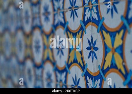 Lisbon's wall unveils intricate tile patterns. Vibrant colors and delicate designs create a captivating tapestry, showcasing the city's rich artistic Stock Photo