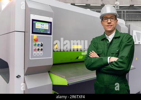 Worker with automatic machine tool in smart factory Stock Photo