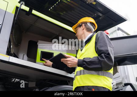 Worker with digital tablet operating construction machine equipment Stock Photo