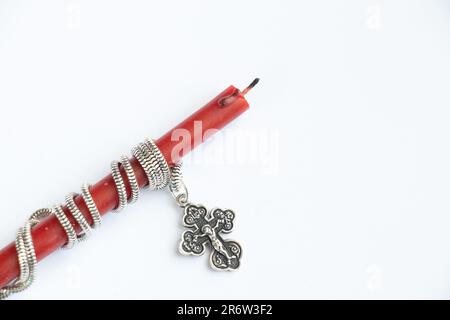 church red candle wound on a silver cross Stock Photo