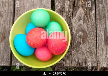 multi-colored easter eggs lie on an old wooden board, on quarantine on Easter Stock Photo