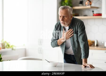 Heart Attack. Senior man suffering from chest pain at home Stock Photo