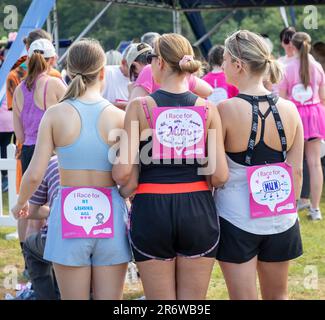 Warrington, Cheshire, UK. Sunday 11 June 2023; Warrington, Cheshire, UK; Race for Life in Victoria Park in aid of Cancer Research. Hundreds of people dressed in pink and competed in different fundraising events in aid of Cancer Research. These girls had a message on their backs explaining who they were running for. Credit: John Hopkins/Alamy Live News Stock Photo