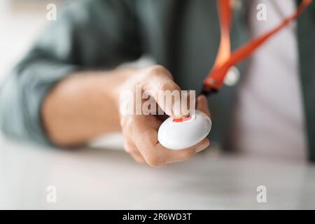 Unrecognizable senior man pushing panic button on emergency equipment Stock Photo