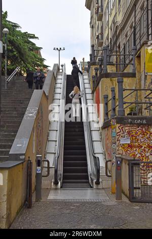 An outdoor public escalator next to steps in a street in Naples, Italy Stock Photo