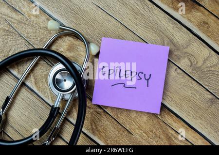 Concept of Epilepsy write on sticky notes with stethoscope isolated on Wooden Table. Stock Photo