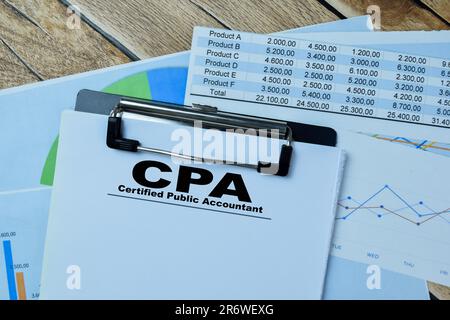 Concept of CPA - Certified Public Accountant write on paperwork isolated on Wooden Table. Stock Photo