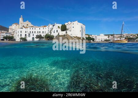 Spain, Cadaques, touristic coastal village on the shore of the Mediterranean sea with seagrass and fish underwater, split view over under water Stock Photo