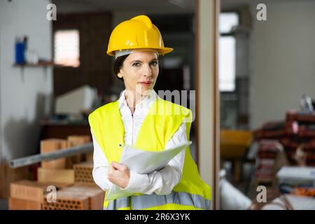 Female supervisor taking notes while inspecting construction site indoors Stock Photo