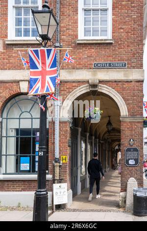 A British flag & the Town Hall Buildings in Farnham - a Grade II listed brick building in an 18th century style with an open arcade ground floor. UK Stock Photo