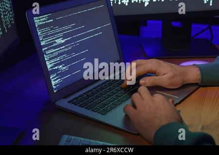 Hacker working with computers at wooden table, closeup. Cyber attack Stock Photo