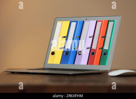 Store and organize information. Modern laptop with hardcover office folders on screen Stock Photo