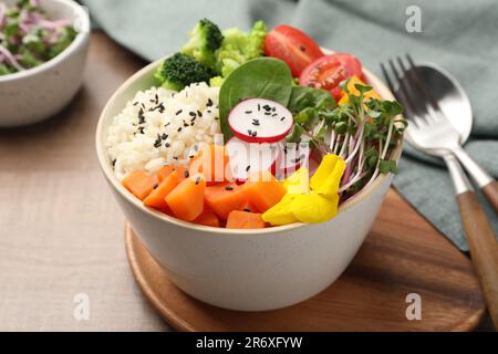 Bowl with many different vegetables and rice on wooden table. Vegan diet Stock Photo