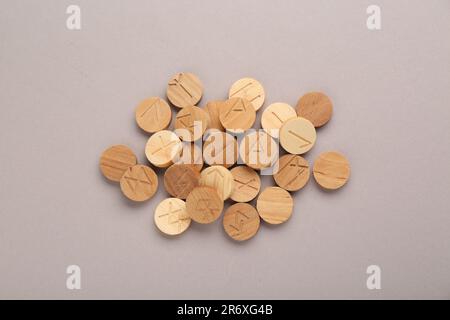 Pile of wooden runes on light grey background, flat lay Stock Photo