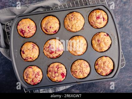 Freshly Baked Raspberry Muffins in a Nonstick Muffin Pan: Breakfast or dessert muffins made with fruit viewed from directly above in muffin tin Stock Photo