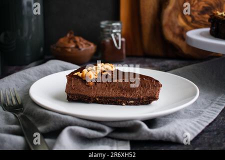 Dark chocolate and hazelnut mousse pie on a white plate with a fork Stock Photo