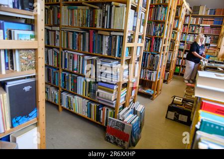 PRODUCTION - 25 May 2023, Saxony-Anhalt, Mühlbeck: Myriam Gödicke sorts a book into a bookshelf in her antiquarian bookshop. The 'Antiquariat Gödicke Alte Schule' has more than 200,000 books sorted into 35 subject areas. Literature fans, book addicts and bookworms are drawn to Germany's first book village - but the antiquarian booksellers have no successors in sight 26 years after its founding. Photo: Klaus-Dietmar Gabbert/dpa Stock Photo