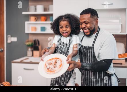 Family members cook homemade pizza dough in funny and playful ways. Mixing ingredients like salt, sugar, milk, yeast, oil then rubbing, massaging, pre Stock Photo