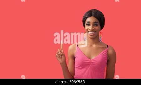 Advertising people. Idea offer. Inspired cheerful smiling woman pointing finger up recommending showing something invisible isolated on pink empty spa Stock Photo
