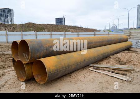 Large iron metal sewer plumbing pipes of large diameter for the industrial construction of water supply or sewage at a construction site during the re Stock Photo