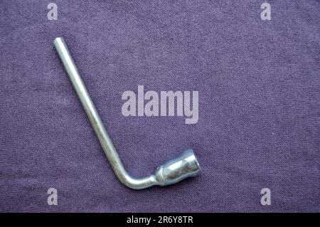 Silver, metal end wrench on a background of purple fabric. Bench tools. Stock Photo