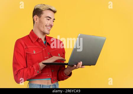Stylish gay man smiling while using a laptop Stock Photo