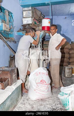 New Delhi, India - November 11, 2011:  bakerman fills flour in the machine to bake bread. Stock Photo