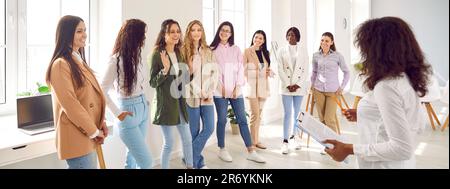 Smiling motivated female participants talking together at corporate meeting Stock Photo