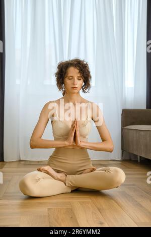 Meditative woman sits in lotus position at home Stock Photo