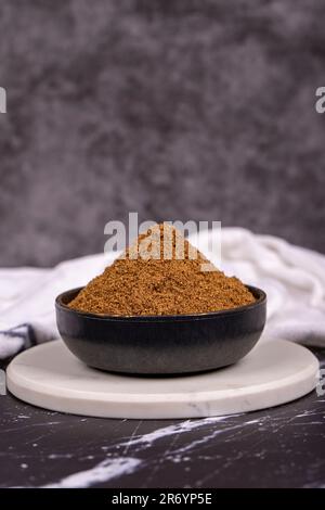 Coriander powder on dark background. Powdered dried coriander in bowl. Spice concept Stock Photo