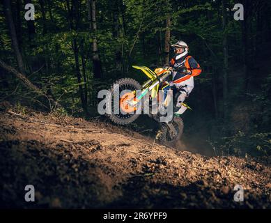 Motorcyclist on a sport motorcycle rides through a difficult forest area Stock Photo