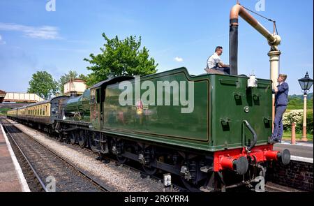 Vintage UK steam train taking on water. Toddington GWR preserved railway station, Gloucestershire, England UK Stock Photo
