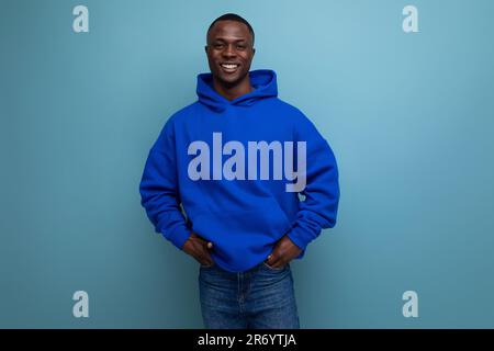 close-up of a laughing black american man in a sweatshirt with a hood on a studio background with copy space Stock Photo