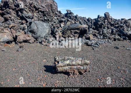 Variety of forms of basalt solidified lava (clinker): hawaiian is main type of lava (aa-lava), viscous lava. Rolling of lava into cylindrical bale at Stock Photo
