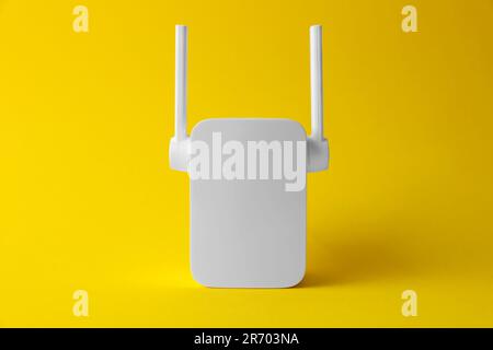 New modern Wi-Fi repeater on yellow background Stock Photo