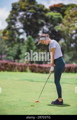 Woman playing golf, Bedugul, Bali, Indonesia Stock Photo