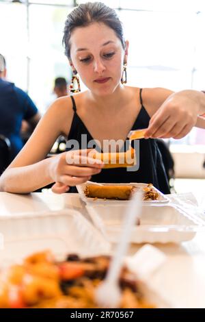 young woman eating spring rolls