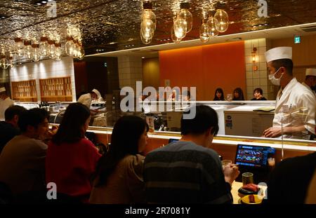 Sitting inside the Kaiten Sushi restaurant in Jingumae, Tokyo, Japan ...